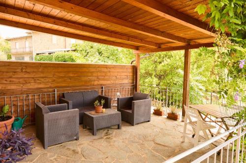 a patio with chairs and a table and a wooden pergola at Il Picchio Rosso in Murlo