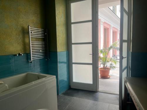 a bathroom with a tub and a sliding glass door at Hotel Terme Neronensis in Pozzuoli