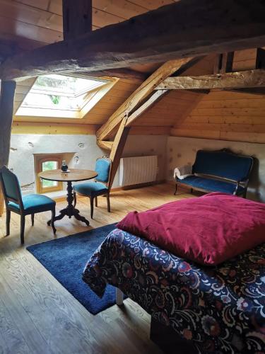 a bedroom with a bed and a table in a attic at Au cordonnier in Troncens