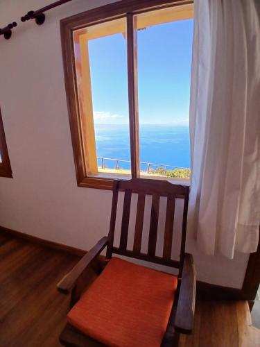 a chair in front of a window with a view of the ocean at Ecolodge Santo Campo in Isla de Sol
