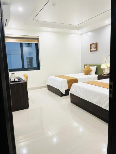 a hotel room with two beds and a window at Sunrise Airport Hotel - Noi Bai Airport in Thach Loi