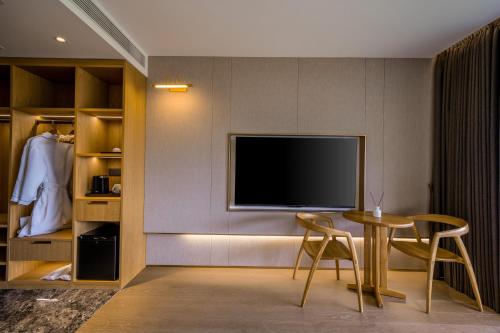 a living room with a tv and a table and chairs at Longji Vista Retreat--Panoramic View of Terrace, Sunrise ,Heated Pool & Affordable Luxury in Longsheng