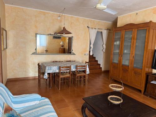 a living room with a table and chairs and a mirror at Villa Francesca in Flumini di Quartu