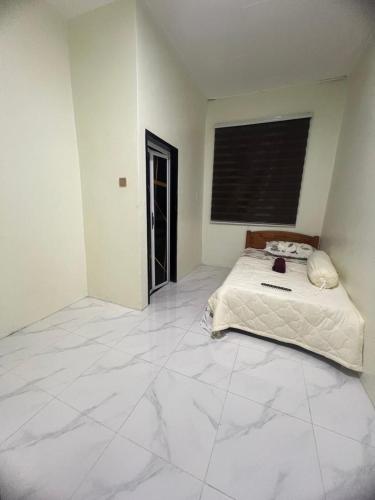 a large white room with a bed in it at Rizqi Homestay Pasir Mas in Pasir Mas