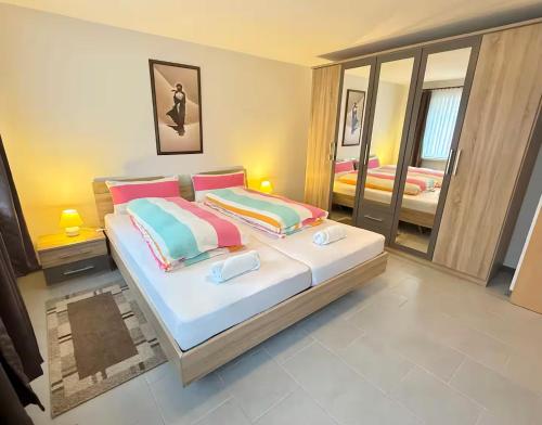 a bedroom with a large bed and a mirror at Cosy Holiday Nest in Marienhafe in Marienhafe