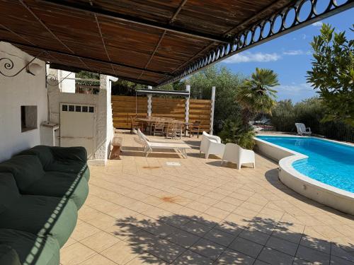 a patio with a table and chairs and a swimming pool at Villa Francesca in Flumini di Quartu