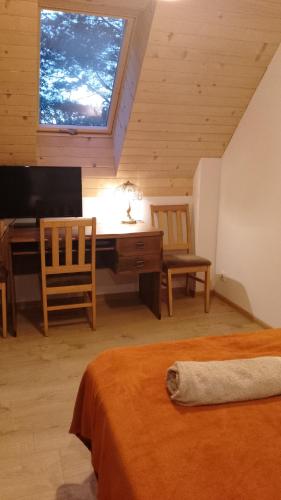 a bedroom with a desk and a piano in a room at Warmia Forest House - Pod koronami drzew in Jedzbark