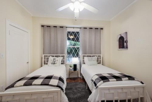 two beds in a room with a window at 438M- 3 BR Apt with Free Parking on Premises and Coffee in San Antonio
