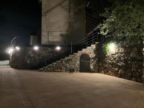 a stone staircase with a stone wall at night at Cascina Elide - Camere vista mare in campagna in Quiliano