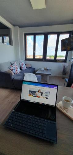 a laptop computer sitting on a table in a living room at Ferienwohnung Hafenpanorama Speicherresidenz Barth 4 5 in Barth