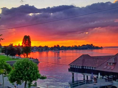 a sunset over a body of water with a building at Studio Marylin in Rorschach