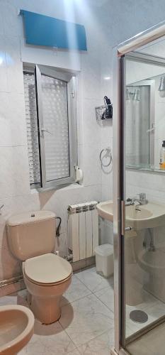 a bathroom with a toilet and a sink and a shower at LIENCRES, céntrico, PLANTA BAJA in Liencres