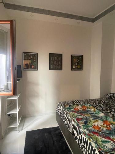 a bedroom with a bed and three pictures on the wall at Minerva Home in Salerno