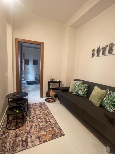 a living room with a black couch and a rug at Minerva Home in Salerno