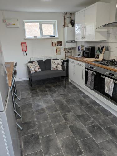 a kitchen and living room with a couch in it at Special Offer CORBY En- Suite Double Room Near Rockingham Min 4 night stay for Couples or Single person Available in Shared property & fully equipped in Rockingham
