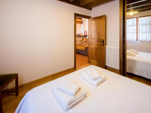 a bedroom with a bed with two towels on it at Apartamentos Rurales Les Martes in Felechosa