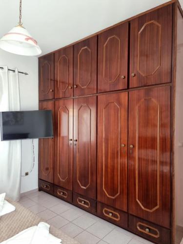 a large wooden cabinet in a bedroom at Drymonas Sunset in Drymonas