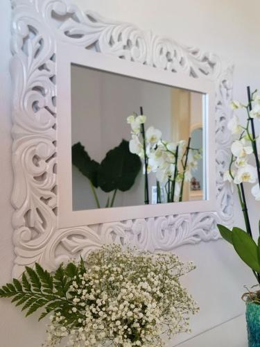 a mirror on a wall with flowers in a vase at Drymonas Sunset in Drymonas