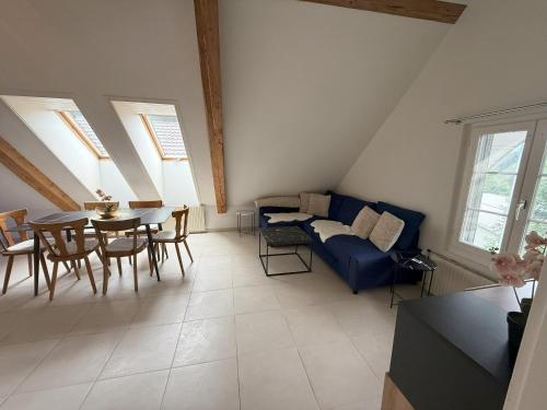 a living room with a blue couch and a table at LOFT WINTERZEIT - NEAR INTERLAKEN SPIEZ THUN - Wandern und Skifahren in Wimmis