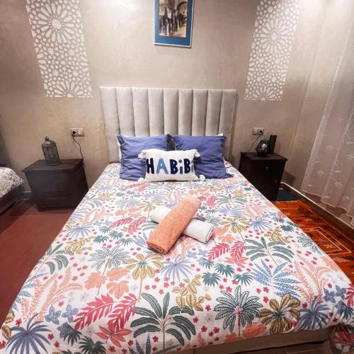 a bedroom with a large bed with a colorful comforter at Appartement proche aeroport in Marrakech