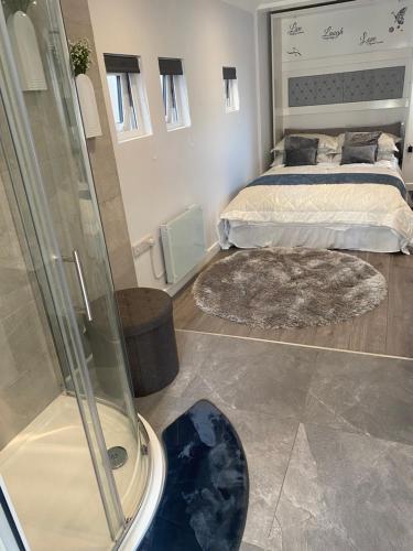a bedroom with a bed and a glass shower at OneDouble room, one small double room, one en-suite studio room near to Wembley stadium in London