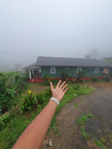 a person with their hand up in front of a house at Blackpool retreat nuwaraeliya in Nuwara Eliya
