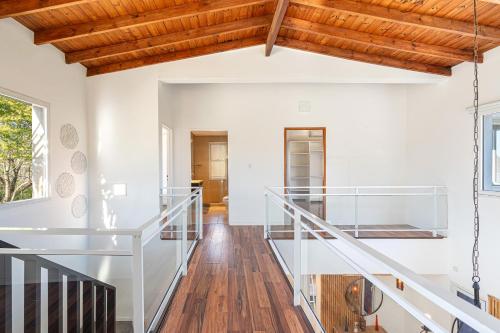 a staircase in a house with white walls and wooden ceilings at Casa Alquiler Tigre Barrio Nordelta 4 dormitorios in Benavídez