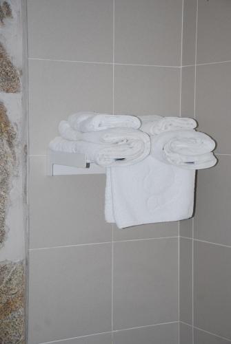 a group of towels on a shelf in a bathroom at Hotel Rustico Casa Do Vento in Bayo