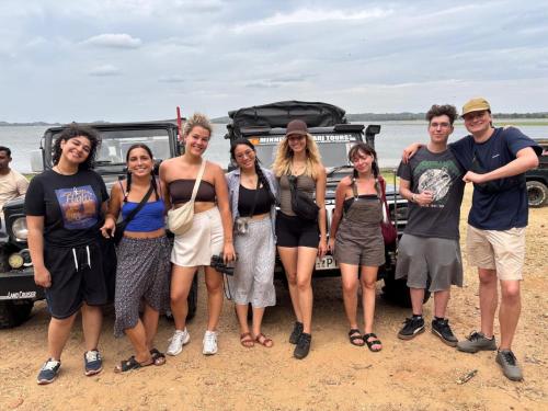 un gruppo di persone che si trovano di fronte a un veicolo di Sigiriya Lions Rest Hostel a Sigiriya