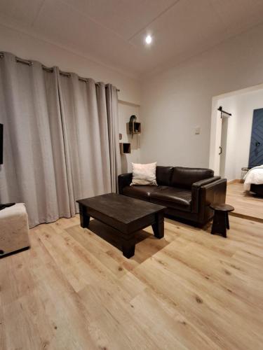a living room with a couch and a coffee table at Forest View Studio Apartment in Pietermaritzburg