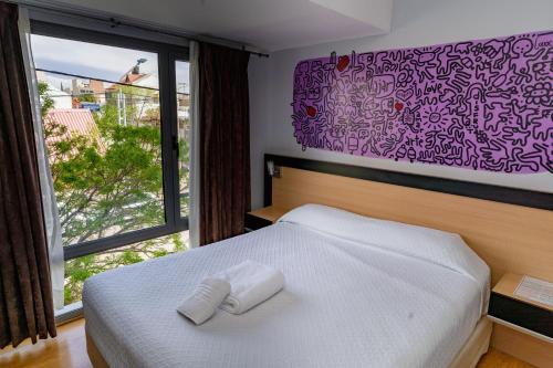 a bedroom with a bed with two towels on it at Apart Hotel Rivadavia 815 in Neuquén