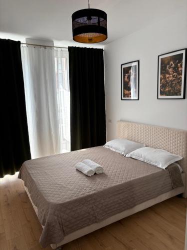 a bedroom with a bed with two towels on it at A&A Appartment 2 in Timişoara