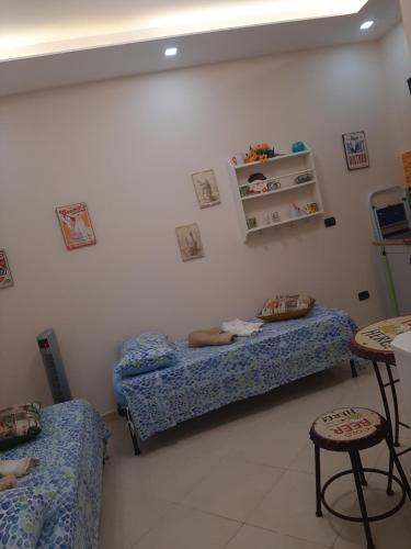 a room with two beds and a table and chairs at Dimora Stabiae in Castellammare di Stabia