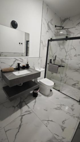 a white bathroom with a sink and a toilet at "Habitaciones Confort La Cuesta" in Las Lagunas