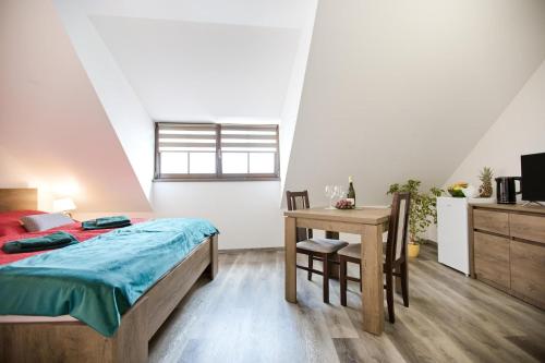 a bedroom with a bed and a table with a desk at Penzion a wellness U Třeboňské madony in Třeboň