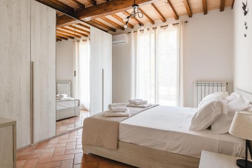 Un dormitorio con una cama grande en una habitación con ventanas. en Appartamento - Il Gelso, en Lucignano