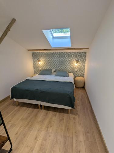 a bedroom with a large bed with a skylight at La Remise loft de caractère et grand garage in Collobrières