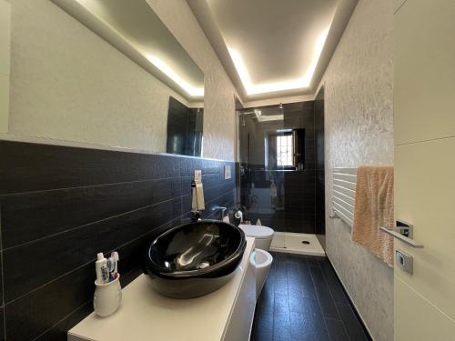 a bathroom with a black sink and a toilet at A Casa di Alice in Ginestra