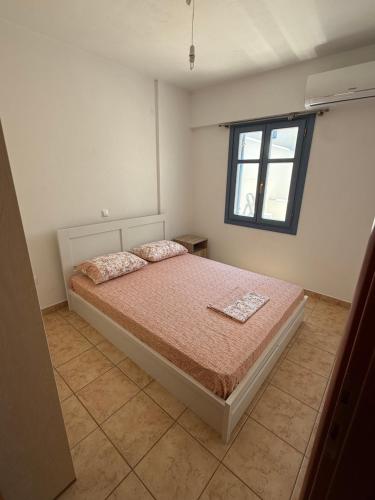 a bedroom with a bed and a window at Naousa house in Naousa