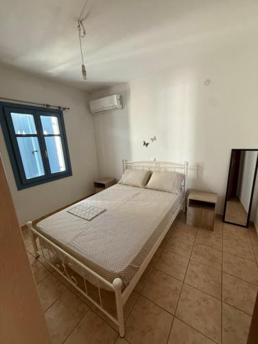 a white bed in a room with a window at Naousa house in Naousa
