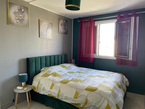 una camera da letto con un letto e una finestra di Chambre lumineuse et cosy, bord de marne, proche Paris a Neuilly-sur-Marne