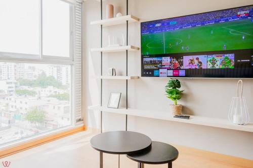a room with two stools and a tv on a wall at Engaging 2BR rooftop view in Barranco in Lima