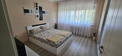 a small bedroom with a bed and a window at Ira's Square Apartment with Free Parking in Skopje