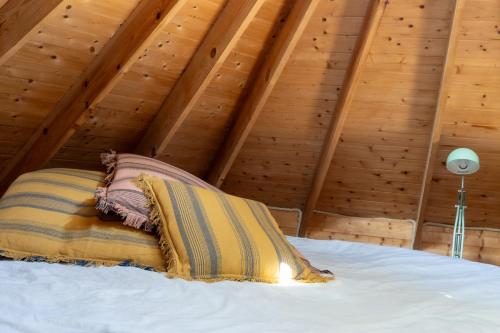 a bed in a room with wooden ceilings at Tinyhouse Hexagonal in Organic Farm in Sintra