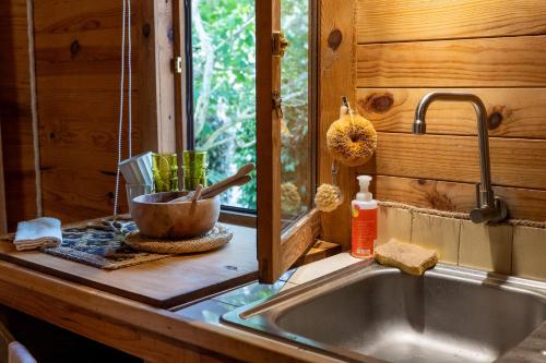 a kitchen counter with a sink and a window at Tinyhouse Hexagonal in Organic Farm in Sintra