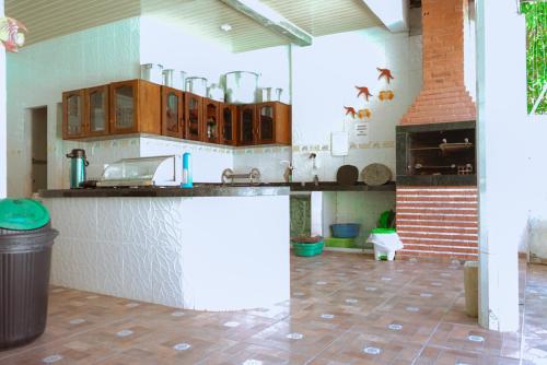 a kitchen with wooden cabinets and a counter top at Pousada Fatimar in Salinópolis