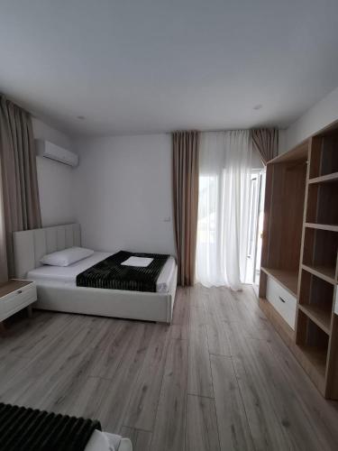 a bedroom with a bed and a large window at Villa Lejzo - Swimming Pool in Berat