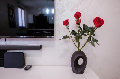a black vase with red roses in it on a counter at Casa vacanza Simona in Salionze