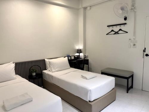 a hotel room with two beds and a table at My House Guesthouse & Restaurant in Bangkok