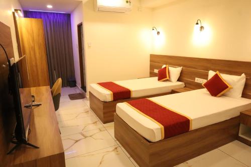 a hotel room with two beds in a room at Shanthi Tourist Home in Pathanāmthitta